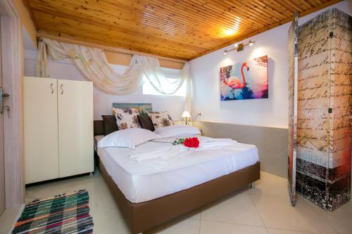 a bedroom with a bed with a flower on it at Villa Elpis 2 in Limenaria