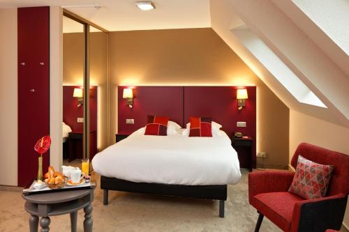 a bedroom with a large bed and a red wall at Hotel Restaurant Crystal in Erstein