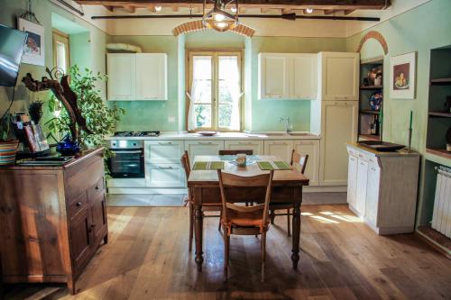 uma cozinha com uma mesa de madeira e uma sala de jantar em Residenza Fra Le Torri - Charme & Art Gallery Home em Arezzo