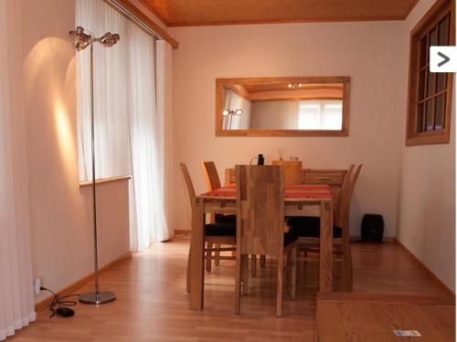 een eetkamer met een tafel en stoelen en een spiegel bij Touring in Grächen
