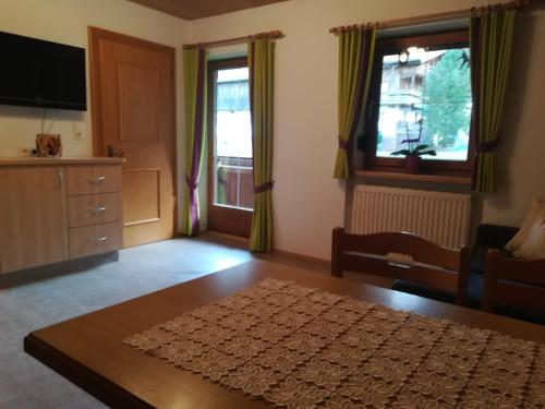 salon ze stołem, kanapą i oknami w obiekcie Ferienwohnung Angererhof w Reith im Alpbachtal