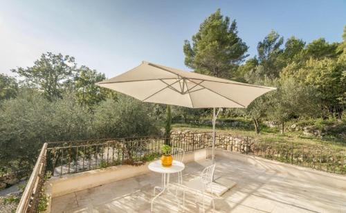 a patio with a table and an umbrella at O PATIO DU MAS in Callas