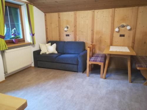 salon z niebieską kanapą i stołem w obiekcie Ferienwohnung Angererhof w Reith im Alpbachtal