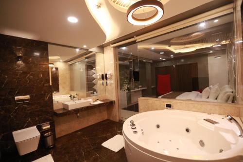 a bathroom with a large bath tub and a sink at Hotel Park Elanza Chennai in Chennai