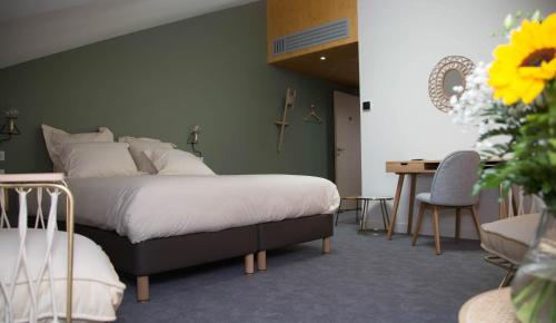 a bedroom with a bed and a table and a desk at Le Patio in Yssingeaux