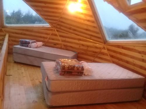 Zimmer im Dachgeschoss mit 2 Betten und 2 Fenstern in der Unterkunft Cabañas y Camping Los Copihues in Ancud