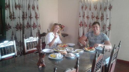 a man and woman sitting at a table with food at Masha Beach Inn in Tangalle