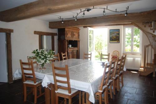 une salle à manger avec une table et des chaises blanches dans l'établissement Gite des Chambauds - Allier - Auvergne -12 pers, à Le Donjon