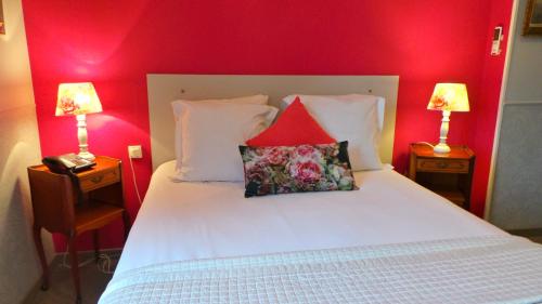 a bedroom with a white bed with red walls and two lamps at Hotel Relais Du Postillon in Antibes