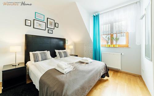 a bedroom with a large bed with towels on it at Wonder Home - Domek górski Karmel z balkonem i kominkiem - dozorowane osiedle z placem zabaw, tuż przy stoku narciarskim in Karpacz