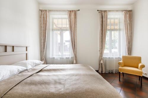 ein Schlafzimmer mit zwei Betten und einem gelben Stuhl in der Unterkunft Vila''RADIUM'' in Druskininkai
