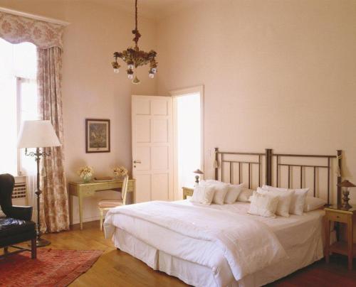 a bedroom with a bed and a chair and a window at El Castillo de Mandl in La Cumbre