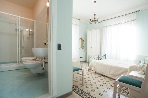 bagno con letto, lavandino e servizi igienici di Liberty Guest House a Lucca