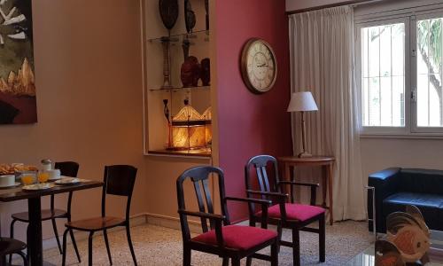 a living room with a table and chairs and a clock at Hotel Luminton in Mar del Plata