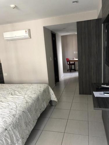 a bedroom with a bed and a desk and a table at Beach Class International - Flat in Recife