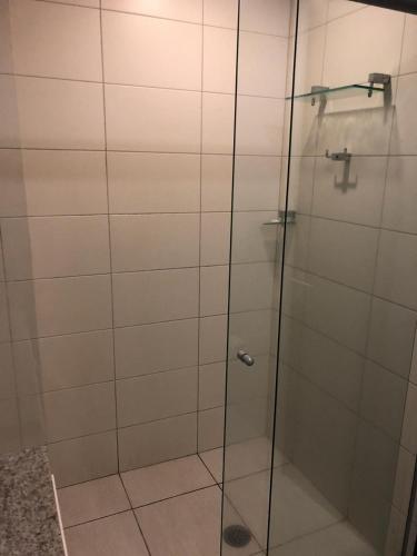 a shower with a glass door in a bathroom at Beach Class International - Flat in Recife