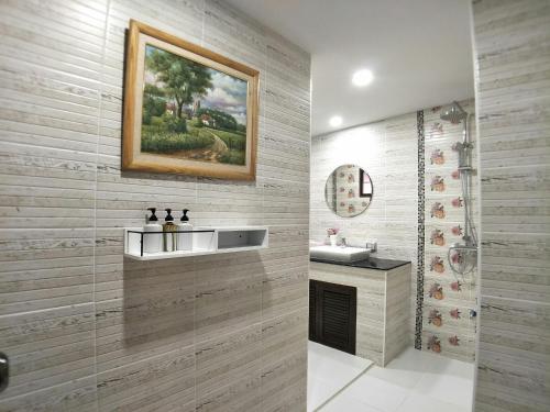Un baño con un lavabo y un cuadro en la pared. en Ban Thong U, The Landmark, en Chiang Mai