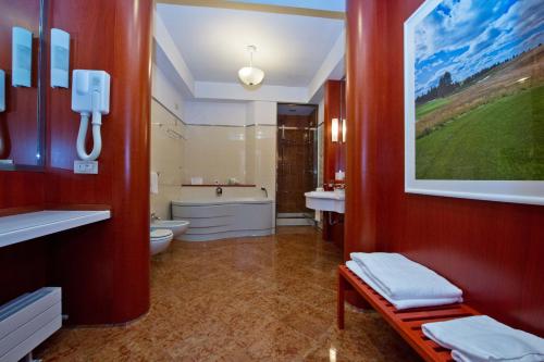 a bathroom with a toilet and a tub and a sink at Golf Club Cavaglià in Cavaglià