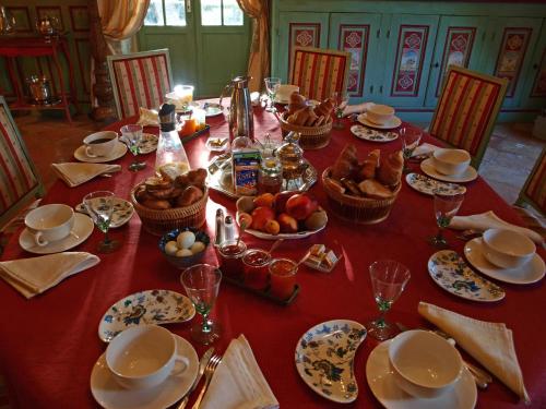 a table with a red table cloth with food on it at La Mouline in Labastide-du-Vert