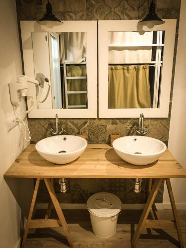 two sinks on a wooden counter in a bathroom at Cantagua Hostel in Valencia