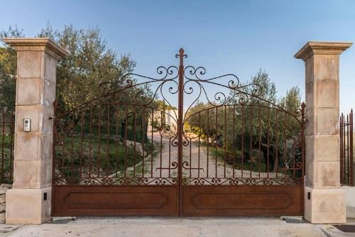an iron gate with a garden behind it at O PATIO DU MAS in Callas