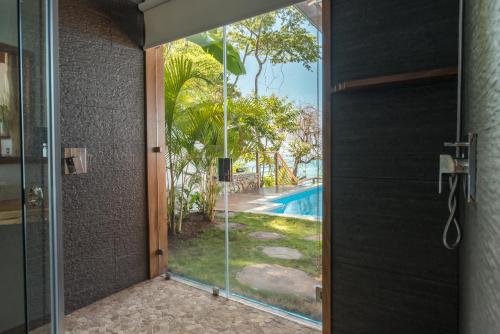 a glass door with a view of a swimming pool at Vista del Alma Boutique - Adult Only in Santa Teresa Beach