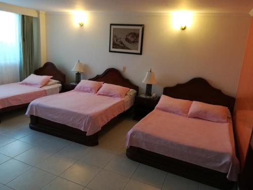 a hotel room with two beds and two lamps at HOTEL COSTA DEL SOL FUSAGASUGa in Fusagasuga