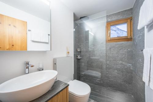 a bathroom with a sink and a toilet and a shower at Casa Alpetta in Flims