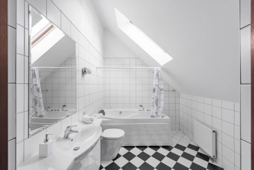 uma casa de banho branca com uma banheira e um lavatório em BURMISTRO NAMAS em Druskininkai