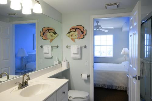 a bathroom with a sink and a toilet and a mirror at Edison Beach House in Fort Myers Beach