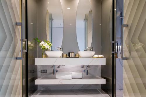 a bathroom with two sinks and a mirror at Savoy Palace - The Leading Hotels of the World - Savoy Signature in Funchal