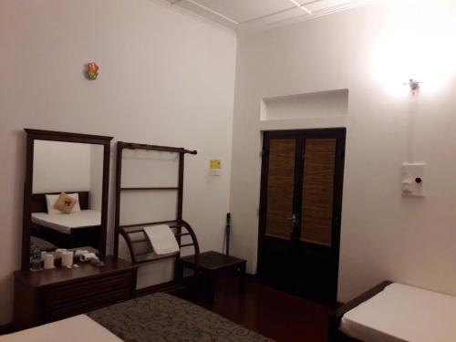 a bedroom with a mirror and a bed and a dresser at Ahangama Eco Villa in Ahangama