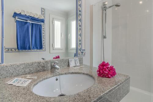 a bathroom with a sink and a mirror and a shower at Apartamentos Parque Tropical en Lanzarote in Puerto del Carmen