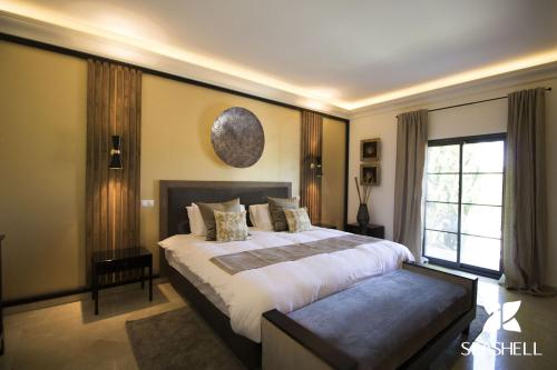 Un dormitorio con una cama grande y una ventana en Villa Esmeralda, en Almancil