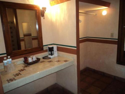 a bathroom with a sink and a mirror at Hotel Hacienda Cazadores in Navojoa