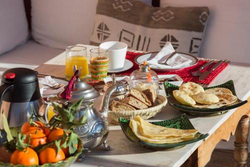 een tafel met ontbijtproducten en drankjes erop bij Riad El Maktoub in Marrakesh