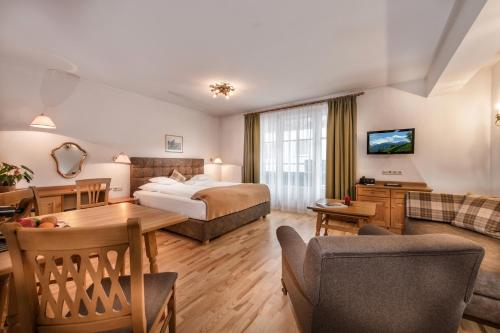 ein Hotelzimmer mit einem Bett und einem Wohnzimmer in der Unterkunft Villa St. Georg in Bad Hofgastein