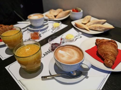 - une table avec des tasses de café, des croissants et des boissons dans l'établissement Ara Suite, à Rome