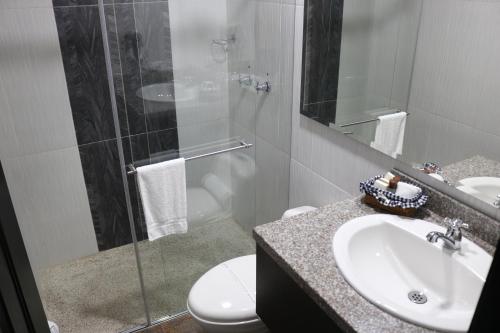 a bathroom with a toilet and a sink and a shower at Beta Hotel in Salento