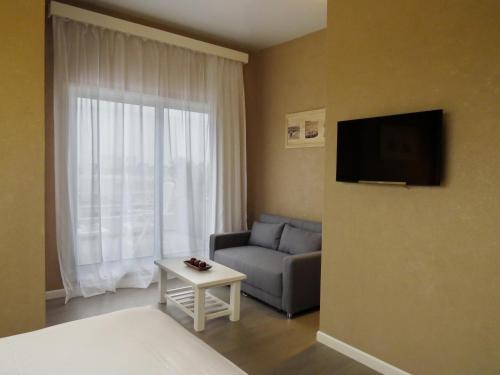 a living room with a couch and a tv at Atlántico Boutique Hotel in Punta del Este