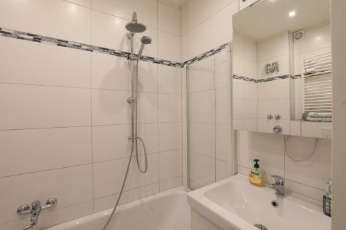 ein Badezimmer mit einer Dusche, einer Badewanne und einem Waschbecken in der Unterkunft Mountain Home Garmisch in Garmisch-Partenkirchen