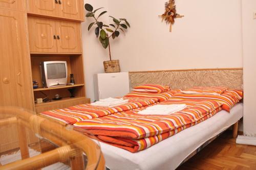 a bed with a striped blanket on it in a room at Vass Vendégház in Eger