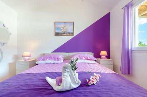Una cama morada con un par de calcetines. en Villa Paradise, en Vela Luka