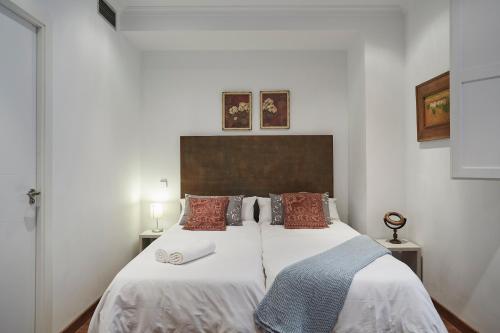 マドリードにあるLEEWAYS APARTMENT IV in ALCALÁ 99のベッドルーム1室(白いシーツと赤い枕のベッド1台付)