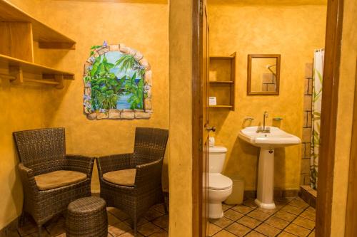 a bathroom with a toilet and a sink at El Sano Banano Beachside Hotel in Montezuma