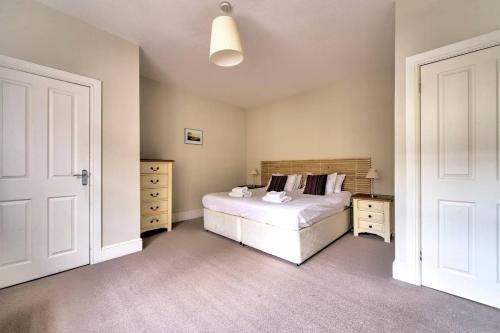 a bedroom with a white bed and two dressers at JOIVY Great Location - Lovely Rose St Apt in City Centre in Edinburgh