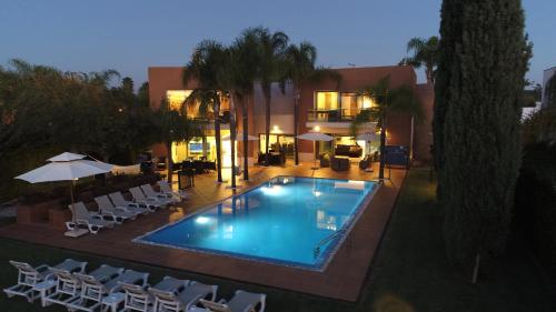 a swimming pool with chairs and a building at Villa Laguna Golf-Frente ao laguna Golf in Vilamoura
