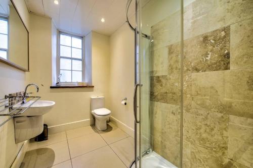 a bathroom with a shower and a toilet and a sink at JOIVY Perfect Location! - Stylish & Cosy Rose St Apt in Edinburgh