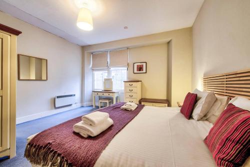 a bedroom with a large bed with towels on it at ALTIDO Perfect Location! - Stylish & Cosy Rose St Apt in Edinburgh