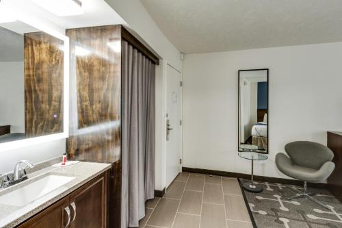 a bathroom with a sink and a chair at Baymont by Wyndham Spokane in Spokane